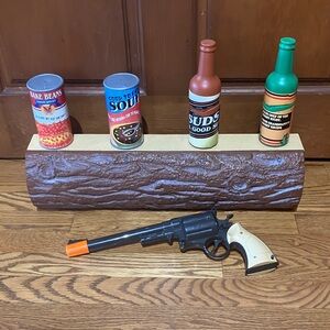 Sharper Image Rustic Log Display with Colorful Cans and Toy Revolver